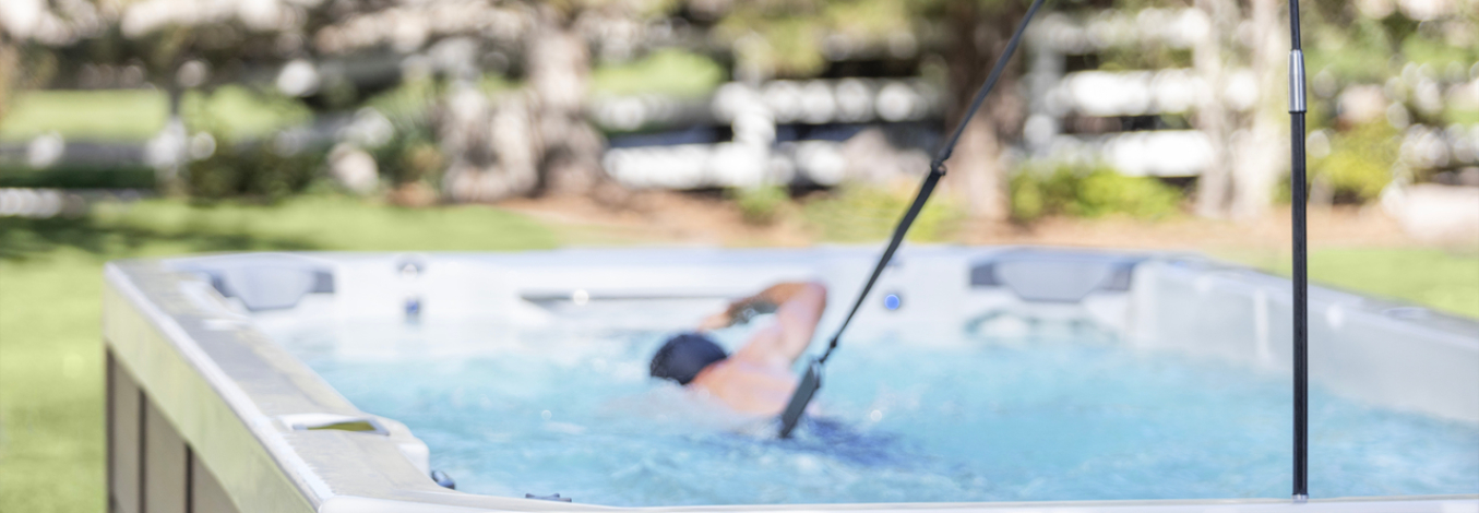 A person freestyle swims in a Swim series spa.