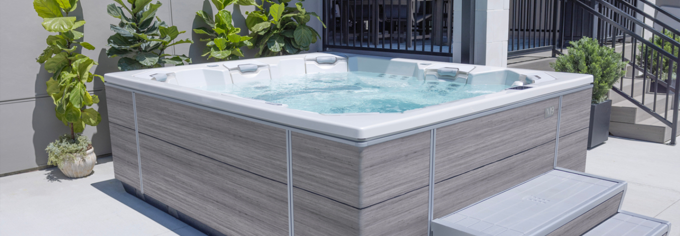 An open M series spa next to an elevated patio area with seating.