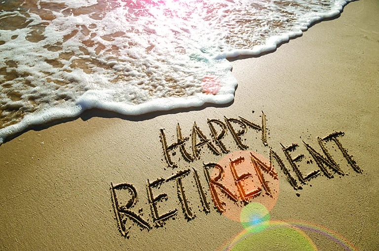 "happy retirement" written in the sand on a beach