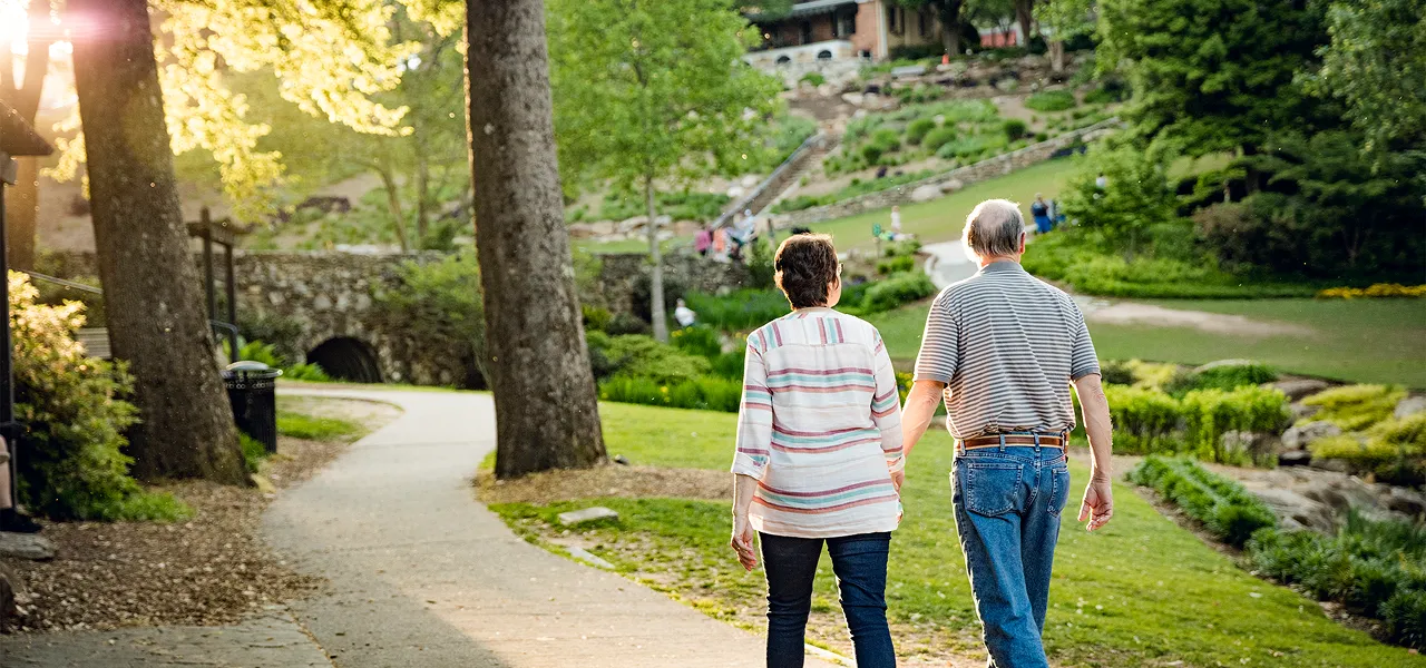 Retired couple walking through a park