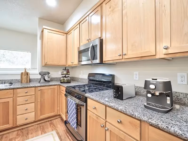 Kitchen with brown wood cabinets featuring stainless steel appliances