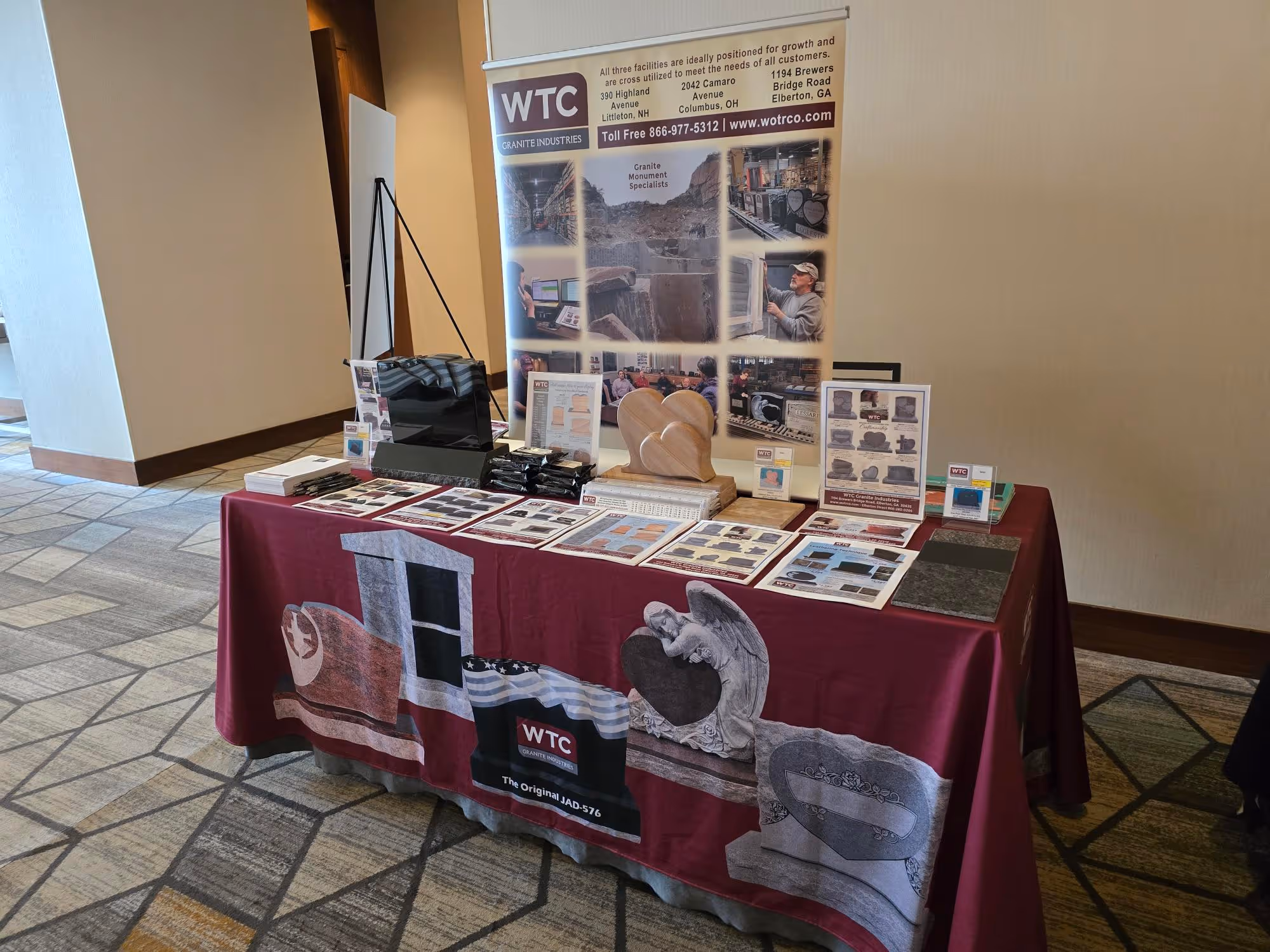 trade show table display for a granite monument company set up in a carpeted hallway