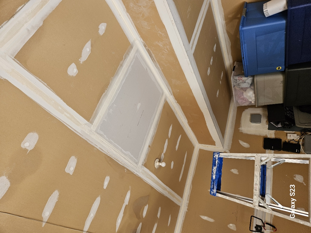 Workers installing drywall during reconstruction