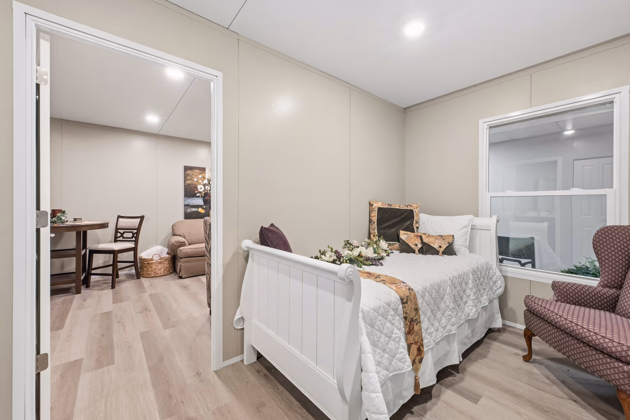 Bedroom view looking into an open living area designed for independent senior living