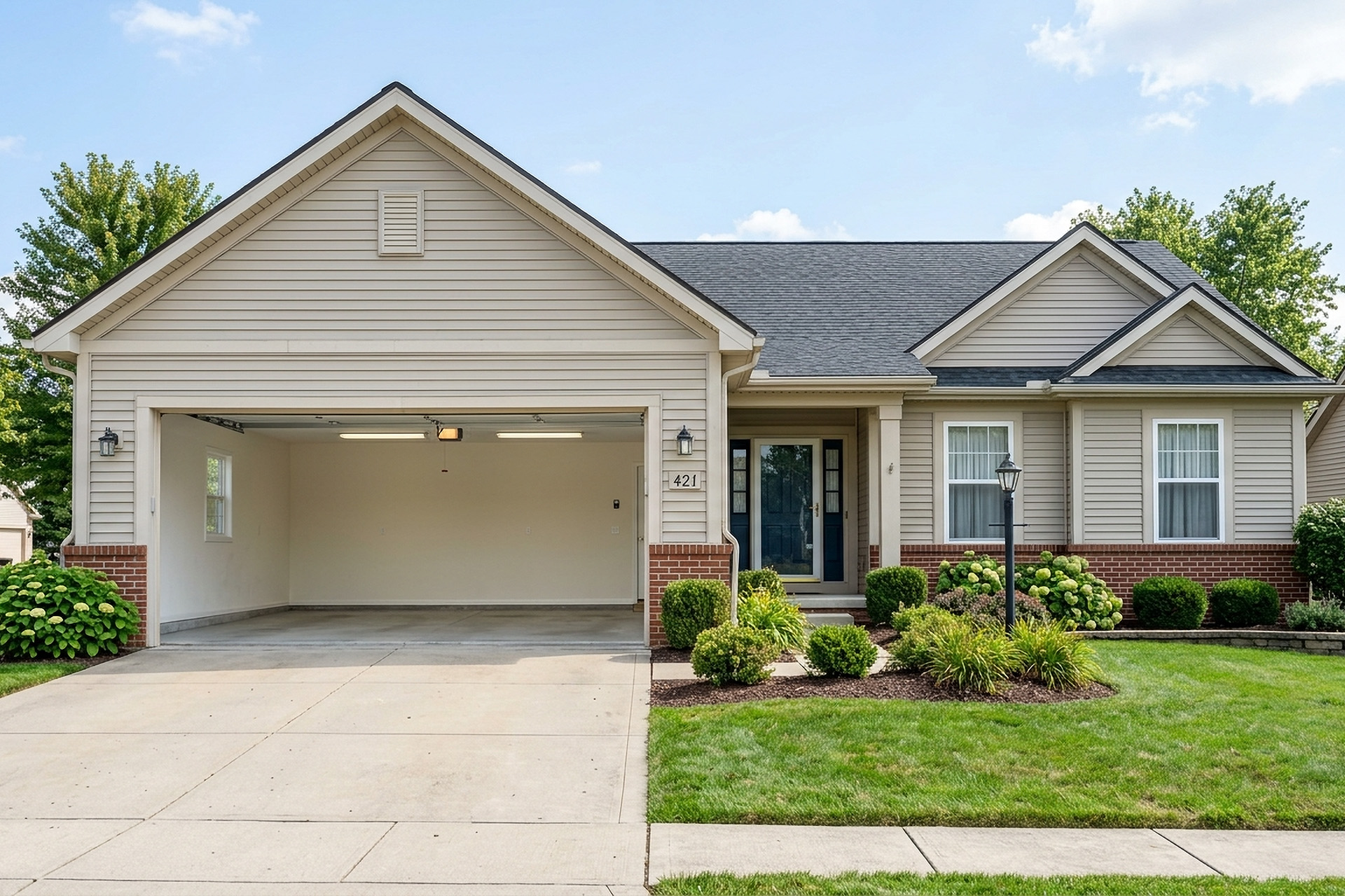 Suburban home exterior with attached garage and front landscaping and empty garage.