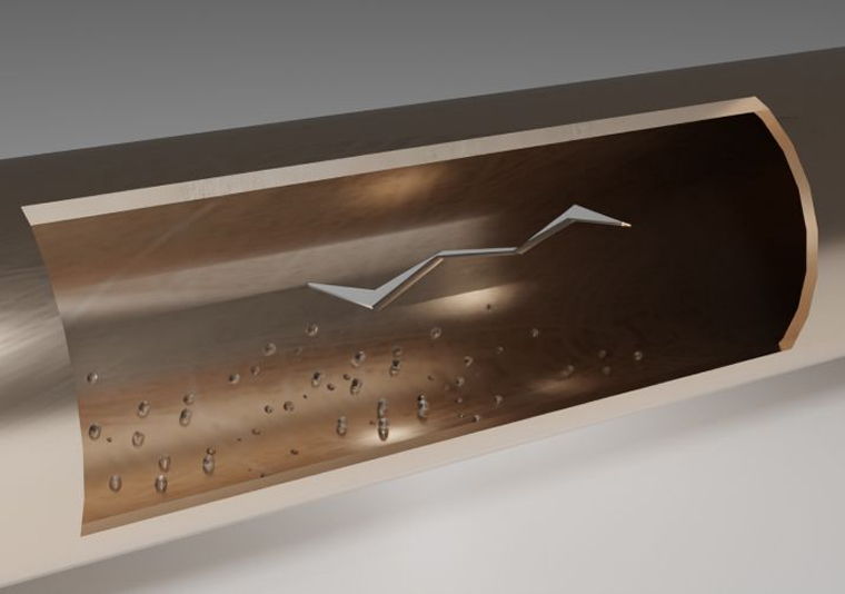 Cutaway view of a pipeline with a metal flow restrictor inside and water droplets on the inner surface.
