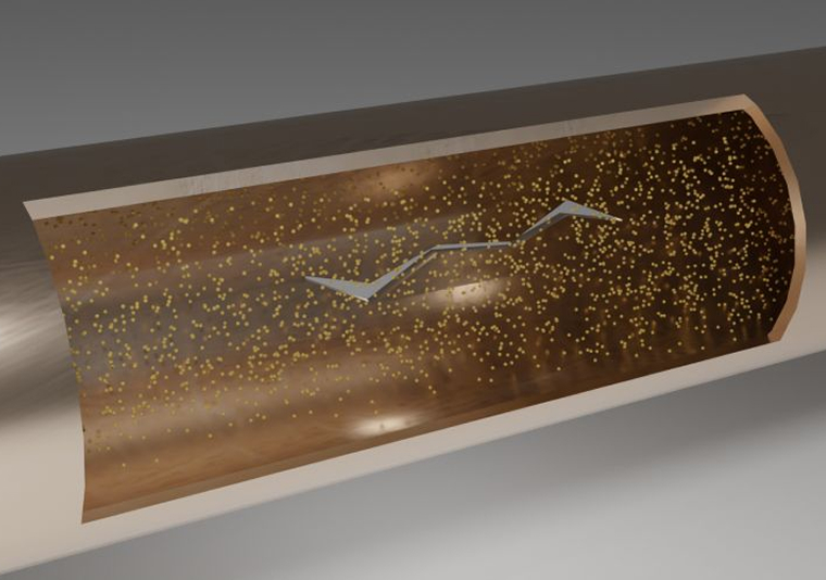 Cross-section of a pipe showing brown liquid with floating yellow particles and a jagged arrow inside.