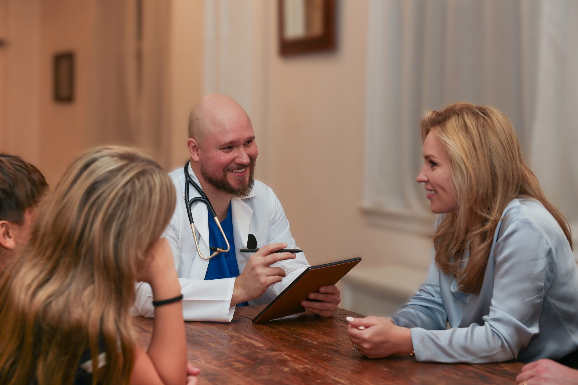 Dr. Dmitriy Gagarkin reviewing results with a family at their kitchen table during a house call
