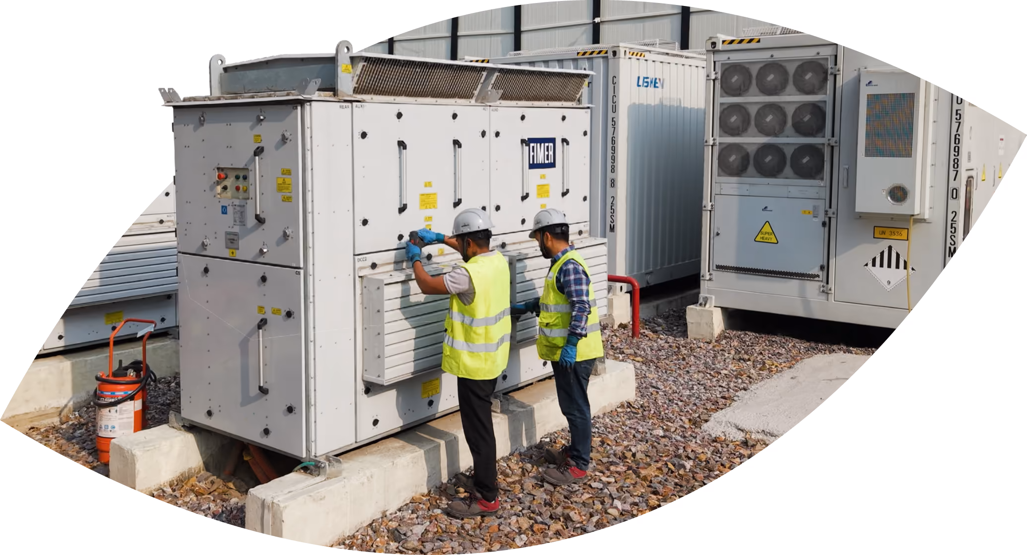 Workers in hi-vis vests and hard hats at an inverter cabinet on the Kilokari battery energy storage site, New Delhi