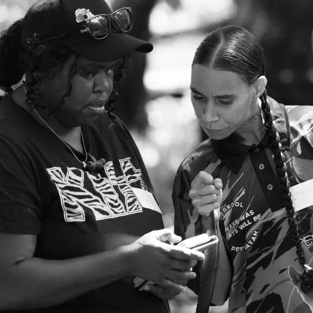 Two Indigital team members reviewing work together on a phone