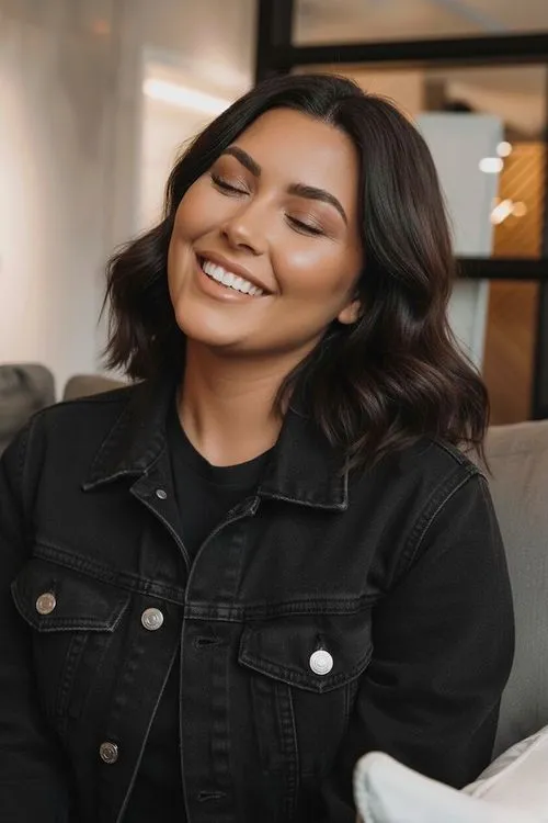 A woman smiling while sitting on a couch.