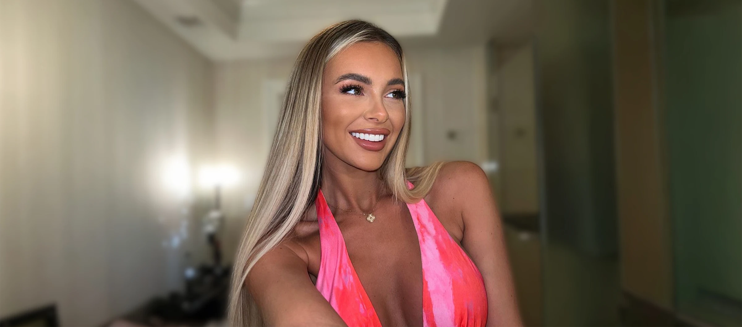 A woman in a pink dress posing for a picture.