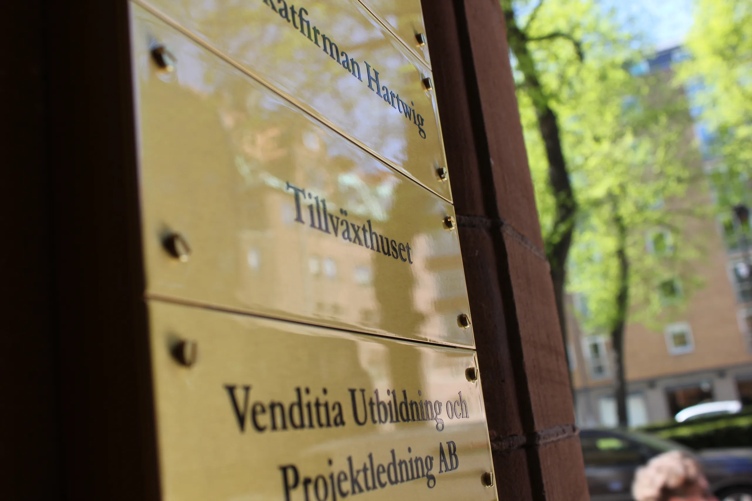 Mässingsskyltar vid entrén till kontoret, med Tillväxthuset ingraverat