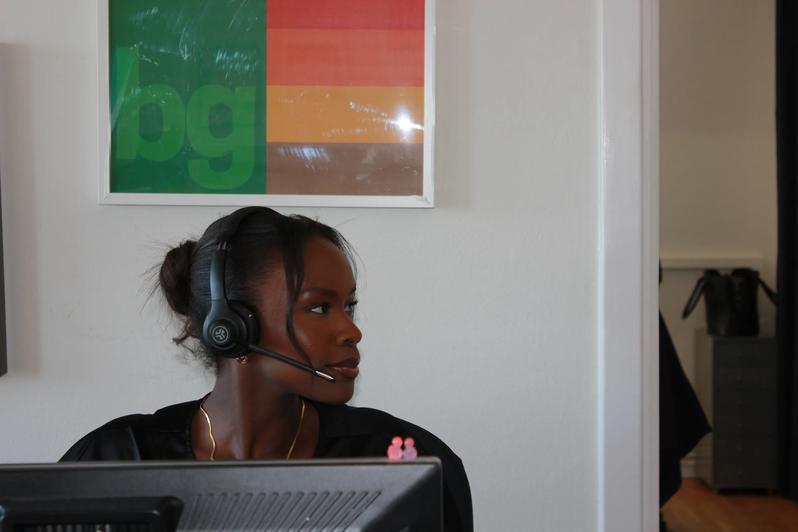 Medarbetare med headset i telefonsamtal vid sitt skrivbord