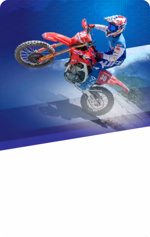 Motorcyclist in blue gear performing a stunt on a red dirt bike against a blue gradient background.