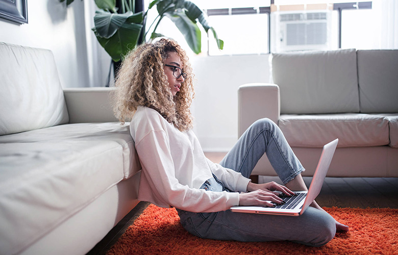 girl sitting on floor working on laptop