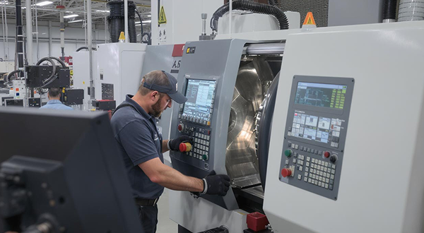 Ein Mann steht an einer modernen Industriemaschine und schließt die Tür.