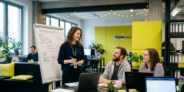 Drei Personen sind zusammen in einem Büro und unterhalten sich.