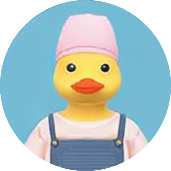 Yellow rubber duck wearing a pink hat, a pink shirt, and blue overalls against a blue background.