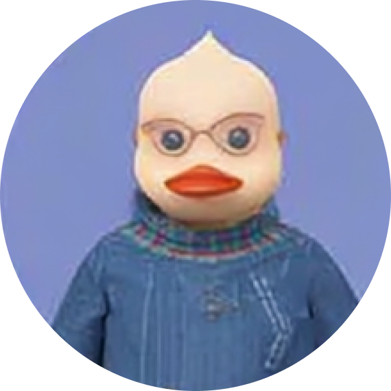 Character with a duck-like face, glasses, and wearing a blue sweater with a colorful collar.