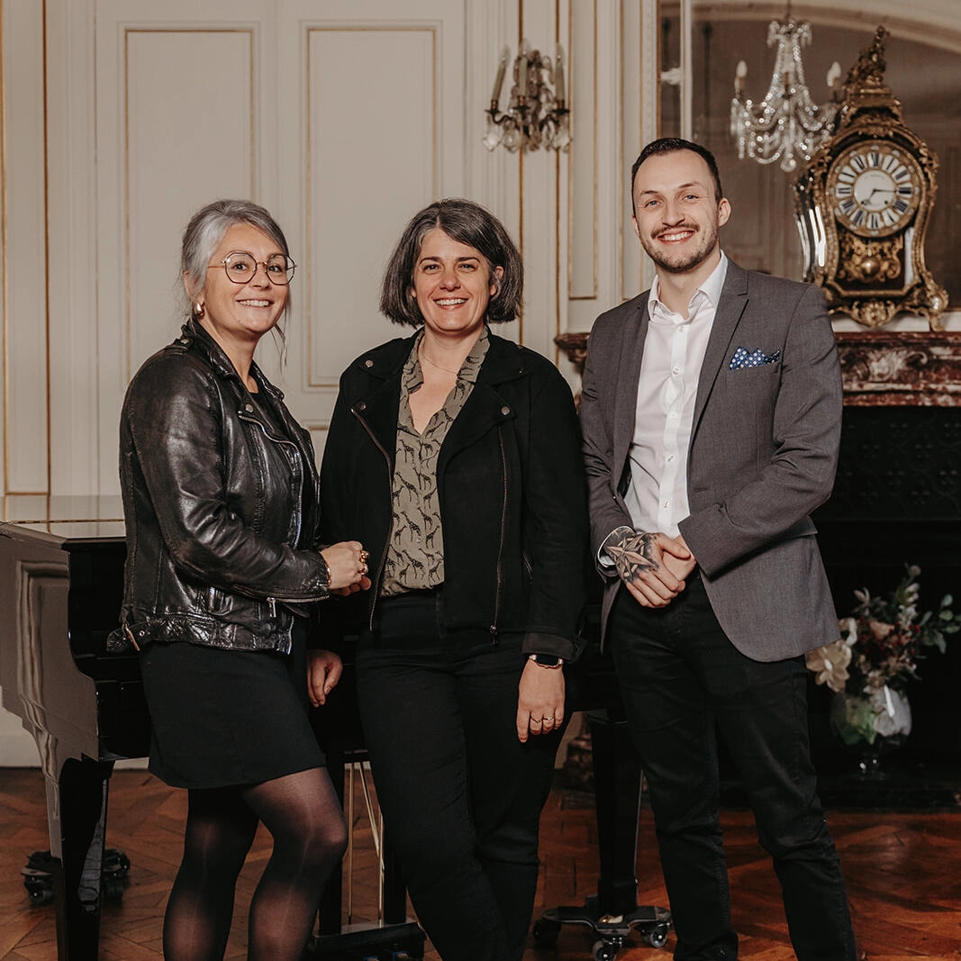 3 personnes debout en train de sourire.