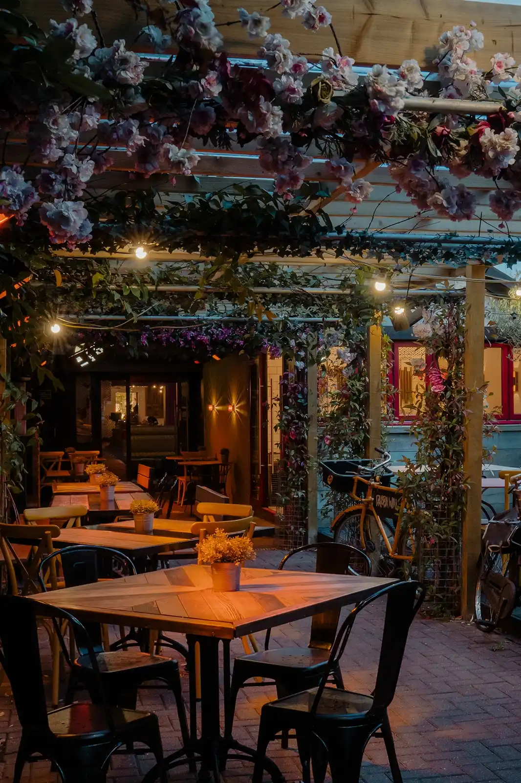 Dabbawal Verandah heated outdoor dining in Jesmond, under a flower-covered pergola with festoon lights