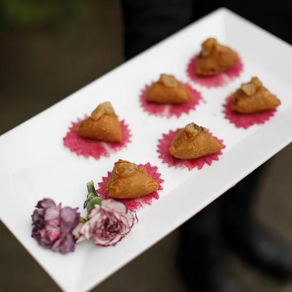 A plated vegetable samosa served at an event catered by Bartleby & Sage