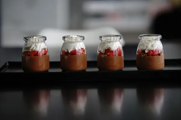 Chocolate mousse pots with strawberries and whipped cream, made by Bartleby & Sage
