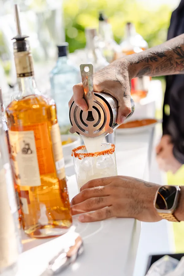 A bartender pouring a custom cocktail at an event catered by Bartleby & Sage