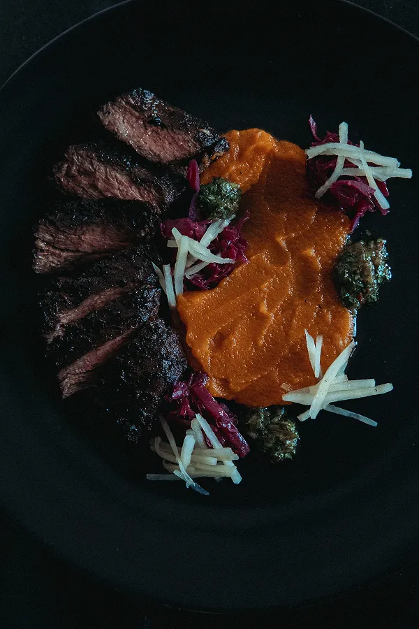 Steak with carrot purée, plated by Bartleby & Sage