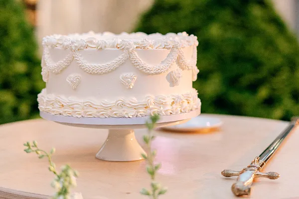 A vintage-style, hand-piped wedding cake at a wedding catered by Bartleby & Sage.
