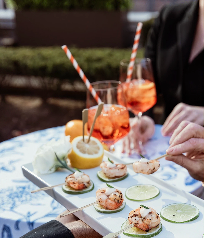 Spritz and shrimp bites being passed around at a corporate cocktail party planned and catered by Bartleby & Sage.