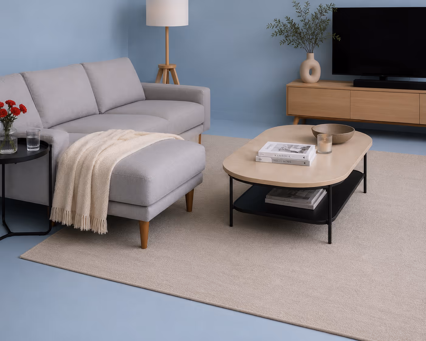 Modern living room with gray sofa, beige rug, wooden coffee table, lamp, and TV console with vase.
