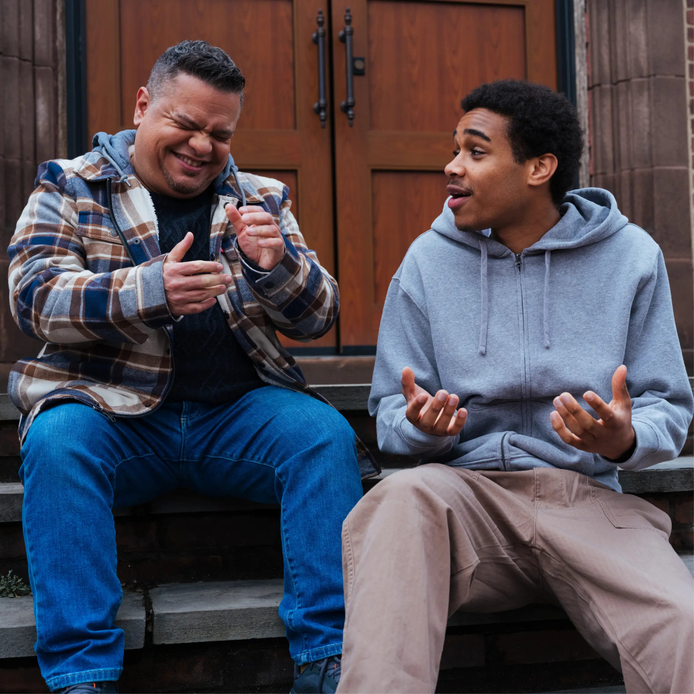 2 Young men laughing and conversing in front of church building