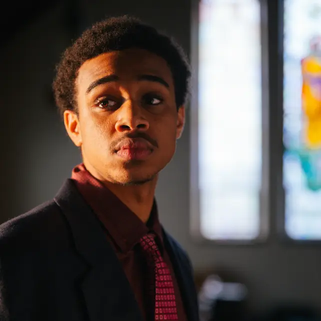 Young man in a suit looking into a light