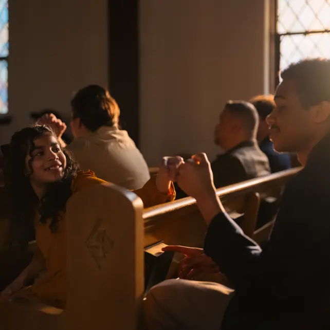 A fist bump between a girl and boy smiling 