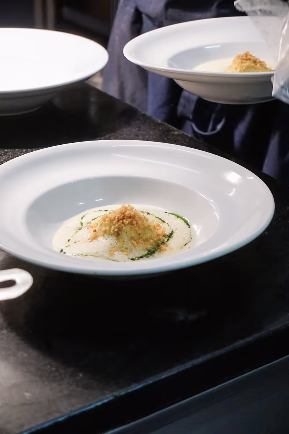 Vorspeisenteller mit Gratin und Kräuteröl auf der Anrichte