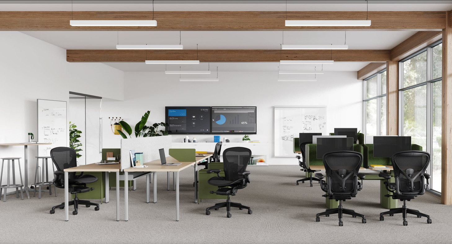 Modern office with ergonomic chairs, desks, large monitors, whiteboards, and natural light from floor-to-ceiling windows.