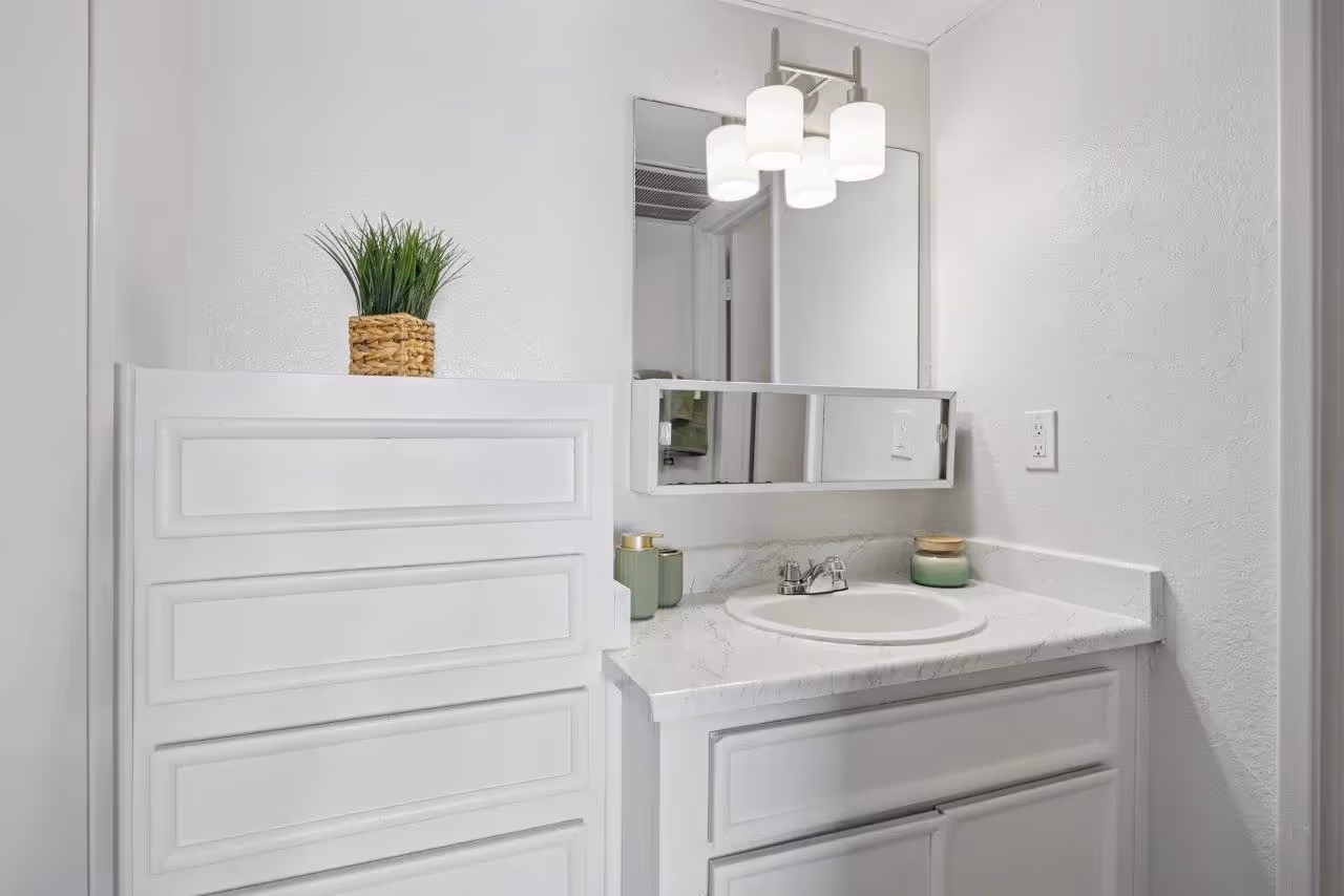 Vanity with white cabinets and mirror