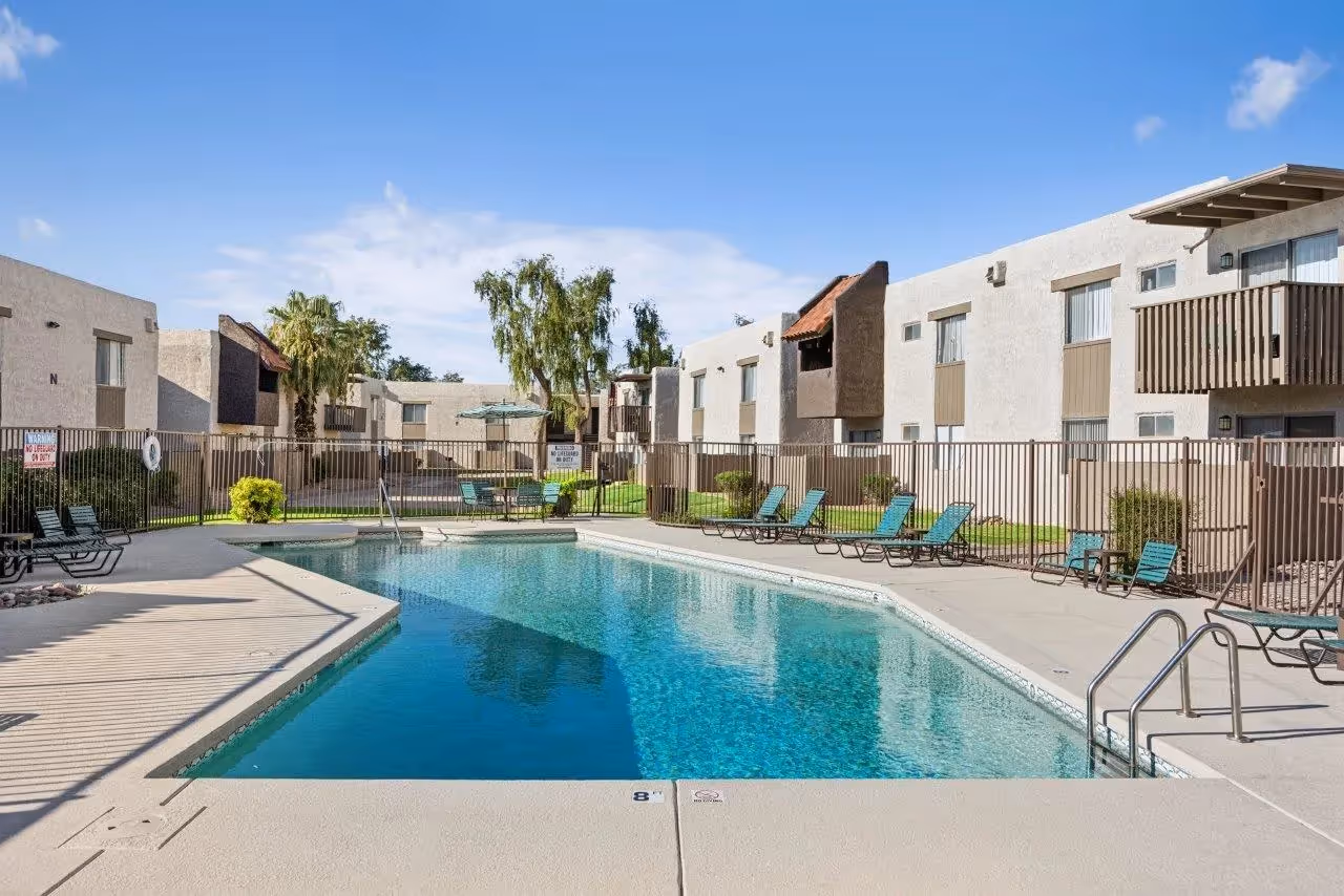 Swimming pool with lounge chairs and table with umbrella