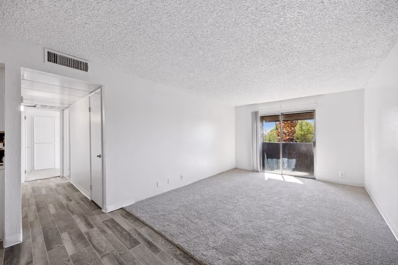 Wide view of living area with carpet and doors to patio