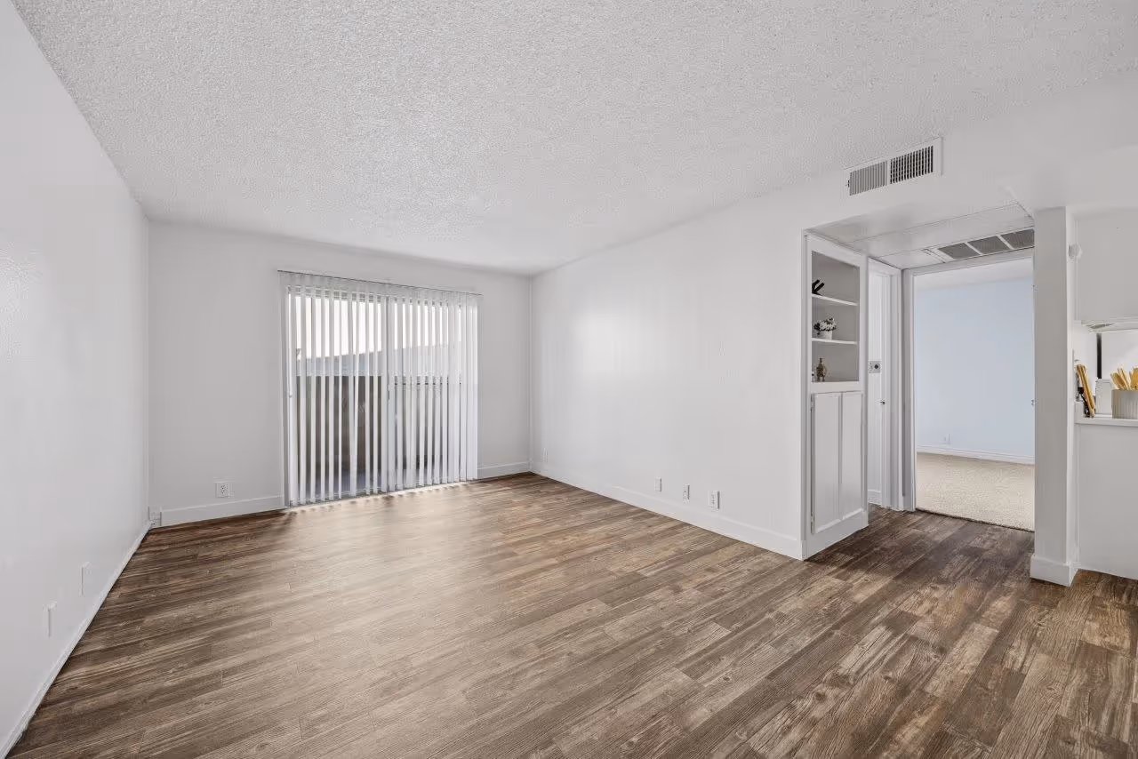 Wide view of living area with wood floors and doors to patio