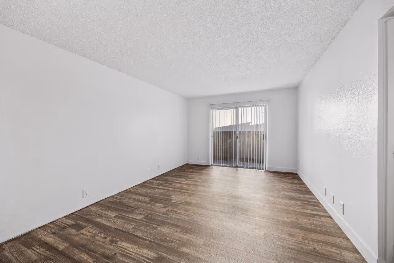 Wide view of living area with wood floors and doors to patio