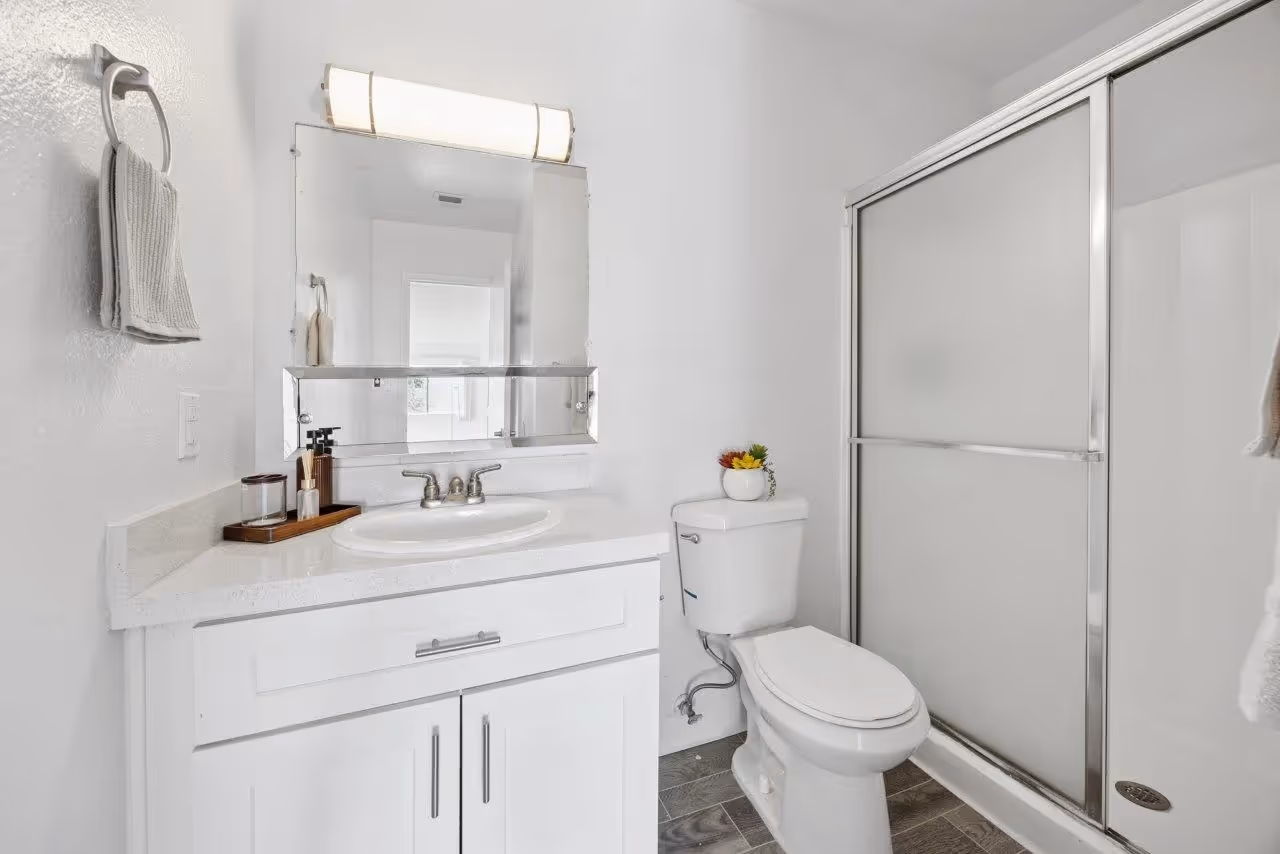 Bathroom featuring shower tub combo, Vanity with sink, mirror, and white cabinets