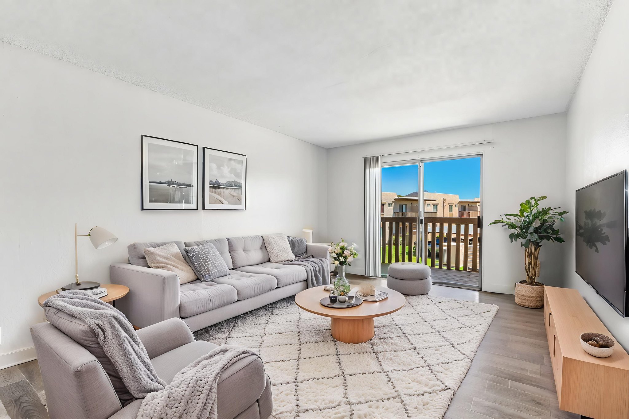 Wide view of living area with furniture, wood floors and doors to patio