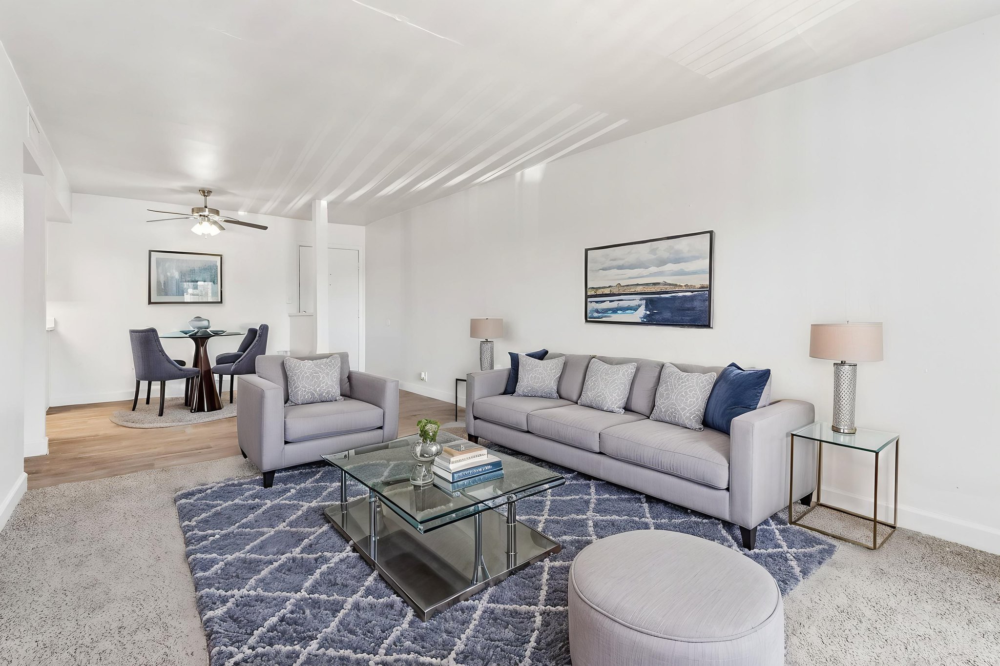 Wide view of living area with furniture, carpet, dining room, and entry way to door