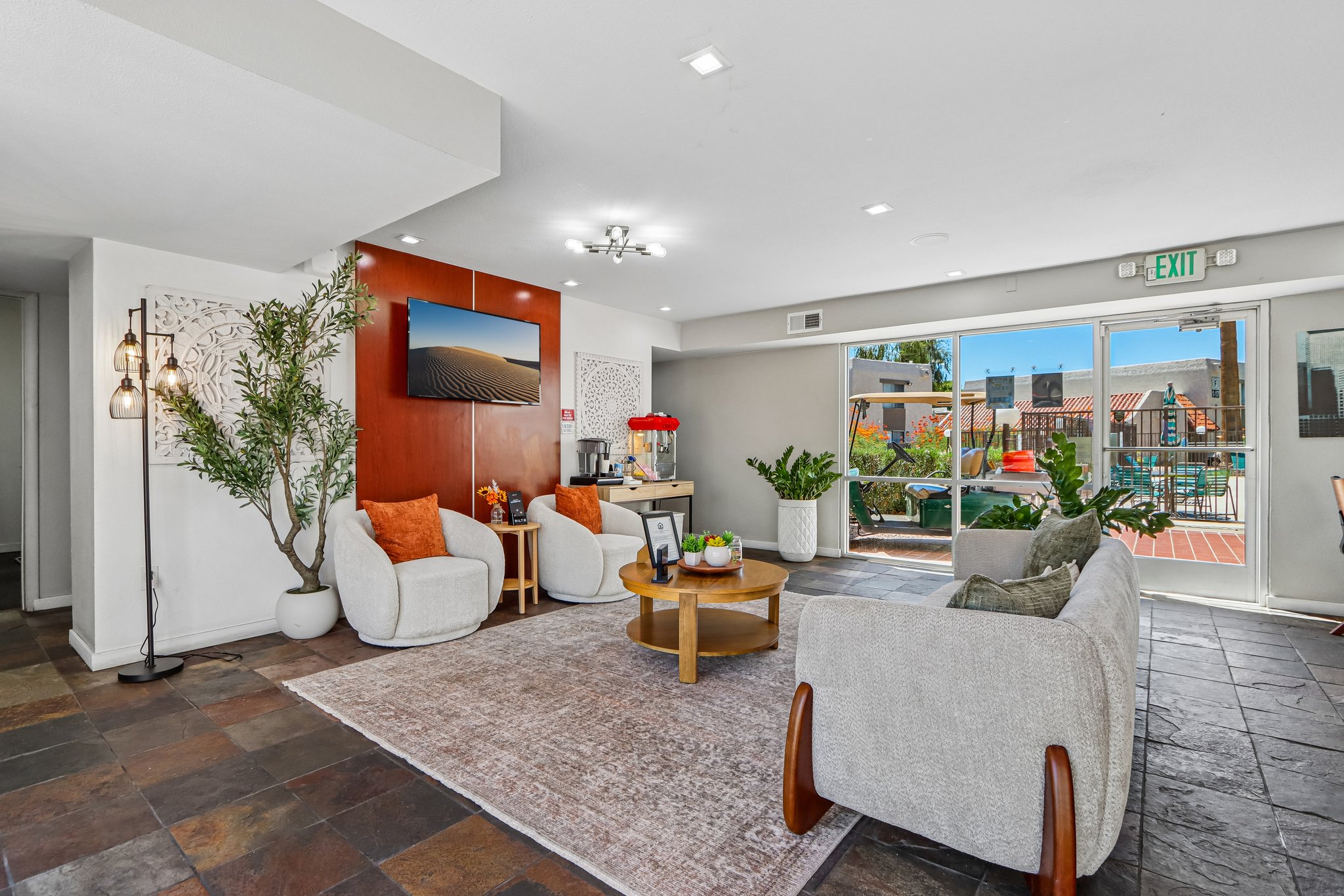 Leasing office with seating area featuring sofa, coffee table, and wall art with logo, tv