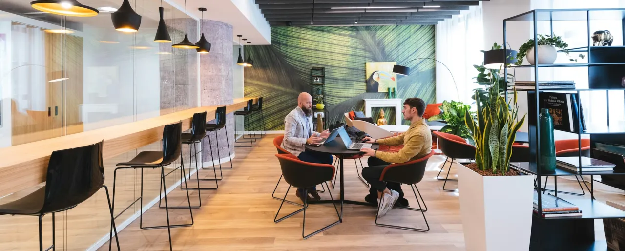 A couple of people sitting at a table in a room.