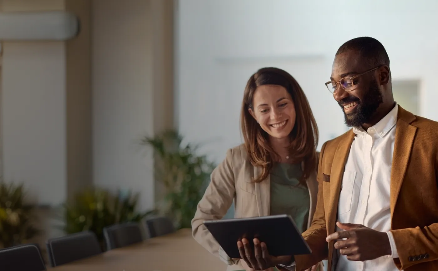A man and a woman looking at a tablet.