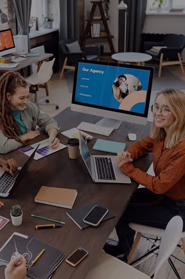 Team of young professionals working and discussing around a table in a modern office.